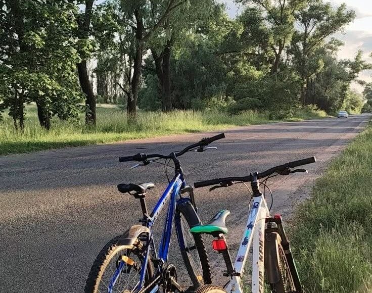 A cyclist commuting on a city road or cycle lane, with a clear eco-friendly vibe (green background, sunrise, or clean streets).